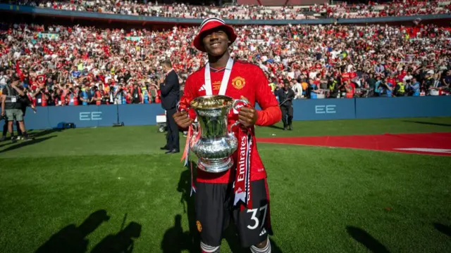 Kobbie Mainoo of Manchester United celebrates with the Emirates FA Cup trophy