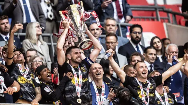 Southampton's captain Jack Stephens holds the trophy aloft