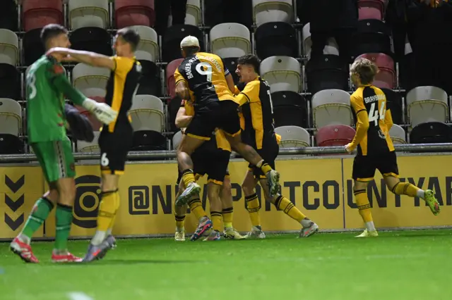 Newport County players celebrating after defeating Gillingham on penalties.