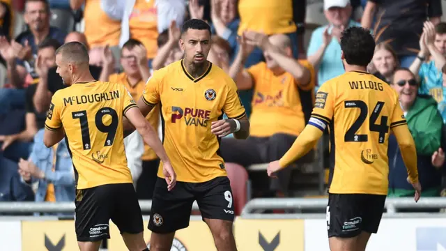 Newport County players Shane McLoughlin and Aaron Wildig celebrate with striker Courtney Baker-Richardson