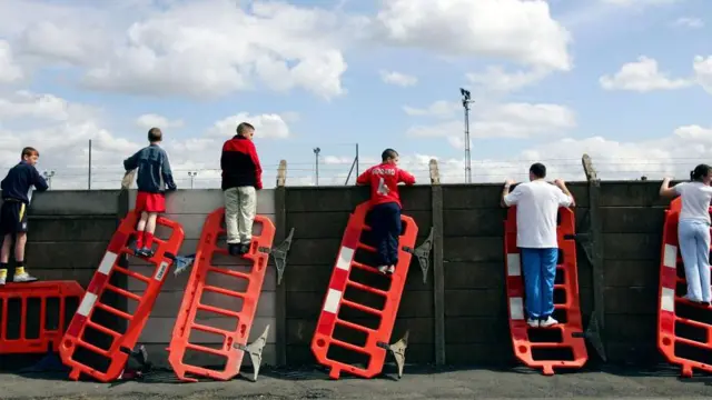 Liverpool fans stand on road barriers to watch training before the 2005 Champions League semi-final