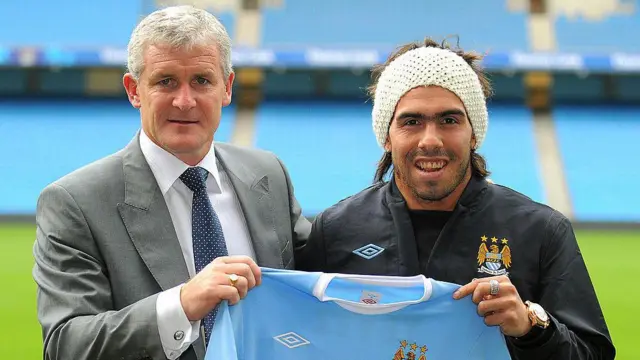 Carlos Tevez poses for photographers with manager Mark Hughes