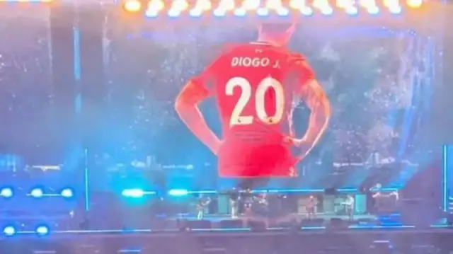 Diogo Jota is shown on the big screen at an Oasis concert
