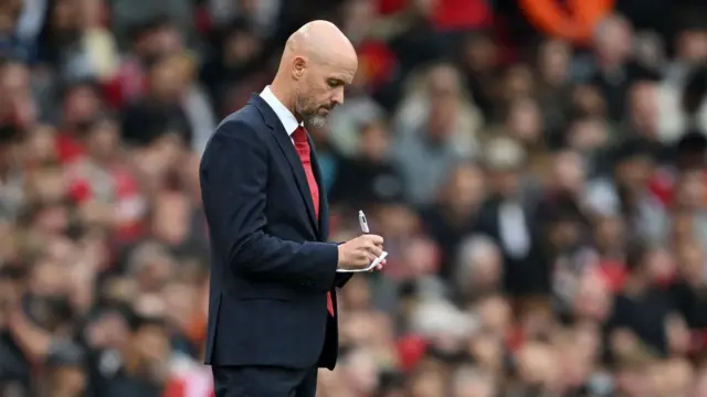 Erik ten Hag, Manager of Manchester United, writes on a notepad 