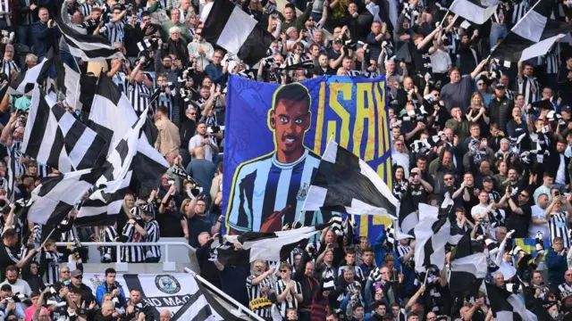 A flag with Alexander Isak on it in the crowd at St James' Park