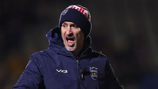 Alan Dickens wearing a Newcastle Red Bulls woolly hat and a big thick Newcastle-branded coat shouting an instruction to his players as they warm-up for a game