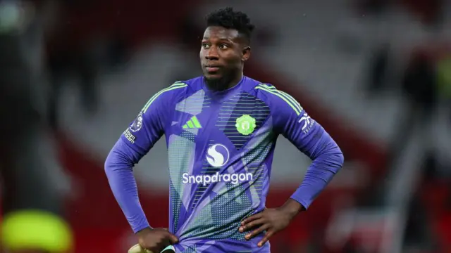 Andre Onana with his hands on his hips and looking dejected