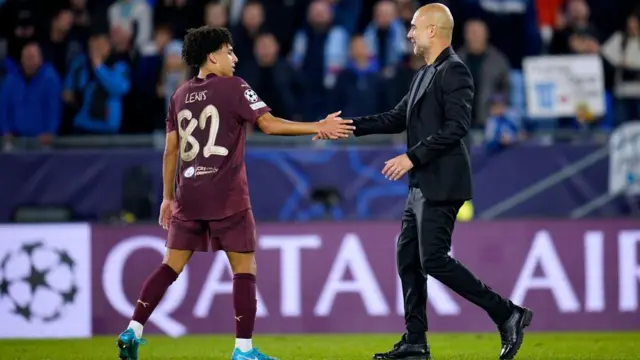 Rico Lewis embraces Pep Guardiola his Manchester City manager after the match