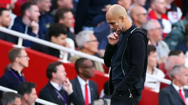 Pep Guardiola looking at the floor during Arsenal v Man City