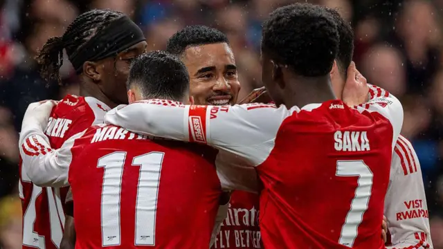 Arsenal players huddle together in goal celebration against Wigan