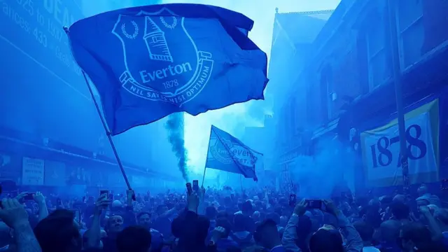 Blue flares and flags displaying 1878 on the Goodison Road 