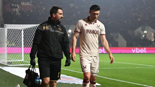 Kieffer Moore hobbling across the side lines alongside medical staff after sustaining a calf injury during Sheffield United's match against Bristol City