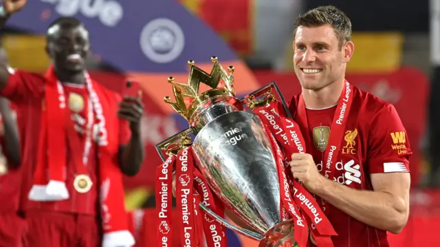 James Milner holds the Premier League trophy while with Liverpool