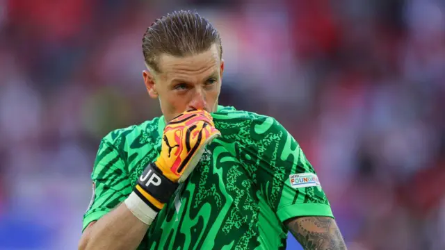 Jordan Pickford kisses his England badge