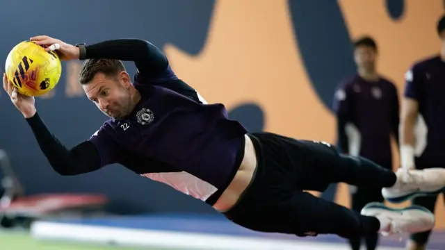 Tom Heaton dives to catch a ball in training