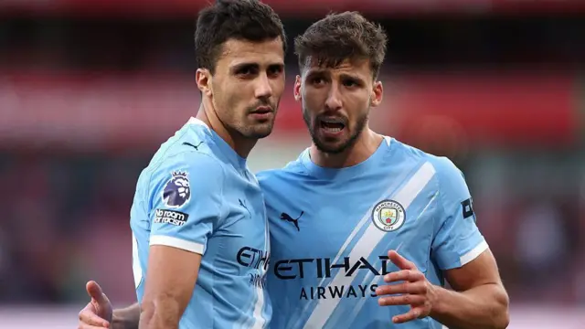 Rodri and Ruben Dias talking on the pitch during a Manchester City match