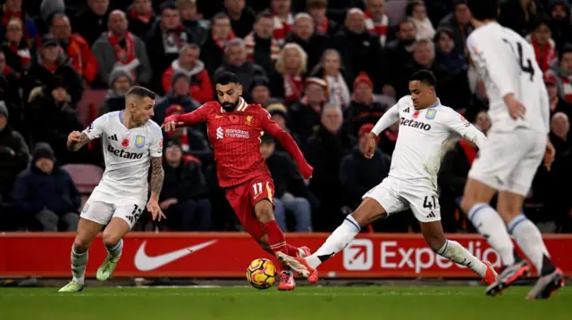 Lucas Digne and Jacob Ramsey challenge Mohamed Salah for the ball