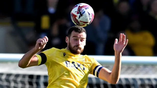 Oxford United captain Elliott Moore heading the ball