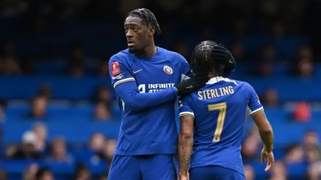 Raheem Sterling is embraced by Axel Disasi