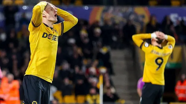 Wolves players with their hands on their heads