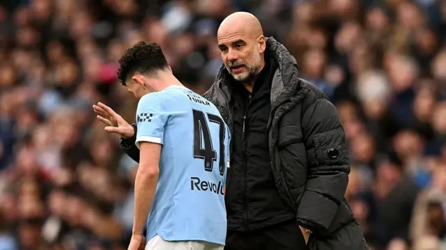 Pep Guardiola talks to Phil Foden