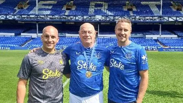 A picture of three men with the arms around each other at Goodison