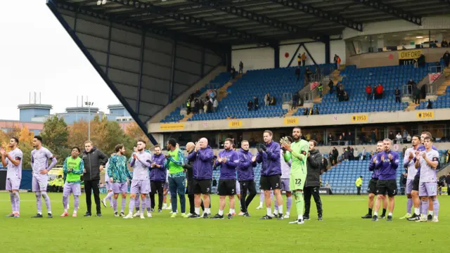 Swansea's players applaud the travelling fans at Oxford