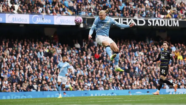 Erling Haaland heads the ball to score Manchester City's first goal