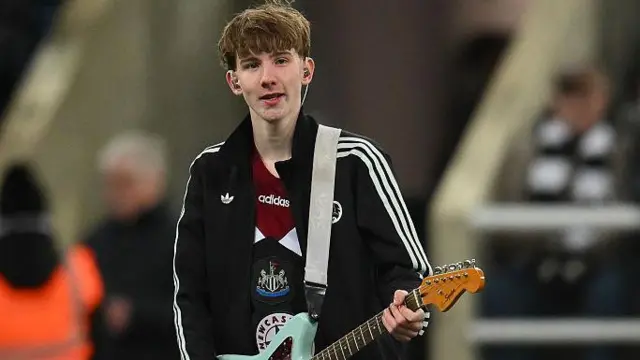 Teenage busker Joe Bartley with his guitar at St. James' Park