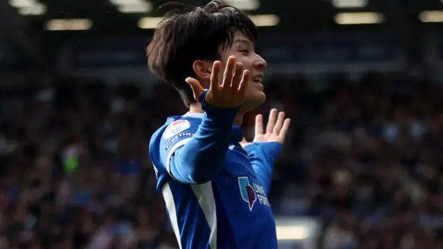 Portsmouth's South Korean Yang Min-hyeok takes the acclaim of the crowd with a smile and his arms aloft