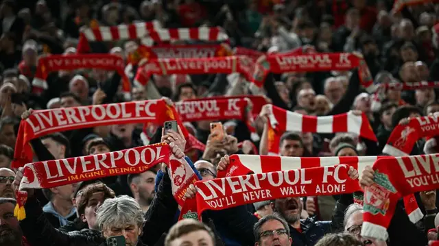 Liverpool fans hold up their scarves