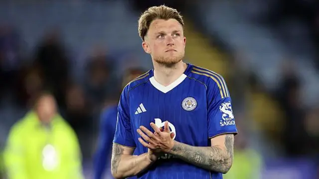 Harry Souttar in blue Leicester City kit applauds fans after a draw against Millwall