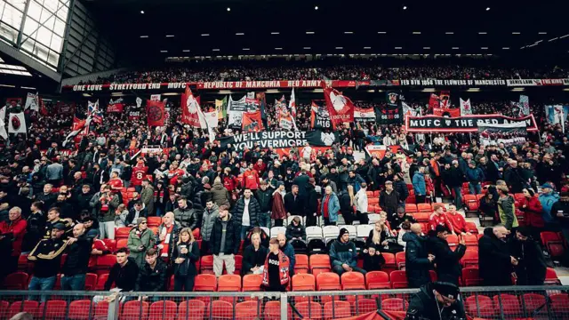 Manchester United fans in a stand supporting the team
