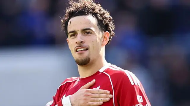 Curtis Jones celebrating by placing his hand over the Liverpool badge on his shirt