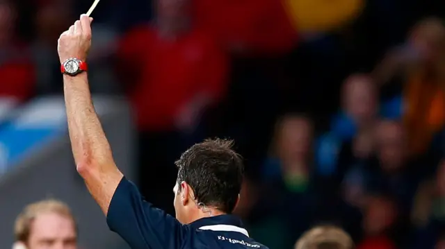 The referee awards the yellow card