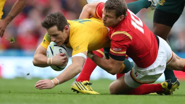 Bernard Foley is tackled by Dan Biggar