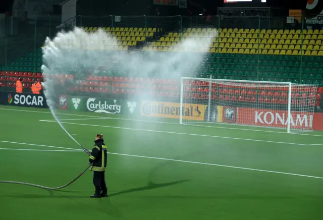 Firemen water the pitch ahead of kick-off