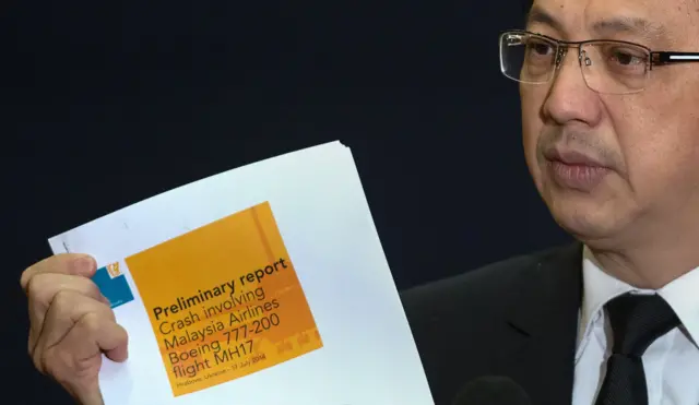 Malaysia's Transport Minister Liow Tiong Lai holds up the preliminary disaster report.