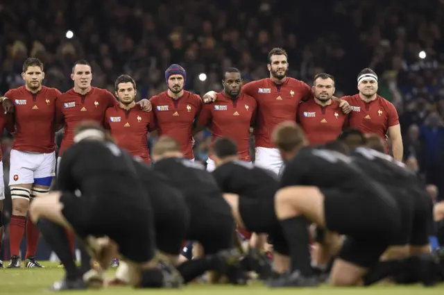 The France team looks on as New Zealand's players perform the haka