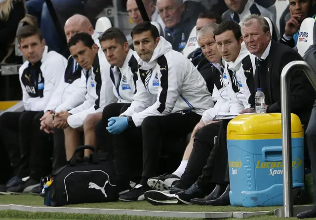 The Newcastle bench looks on at half-time