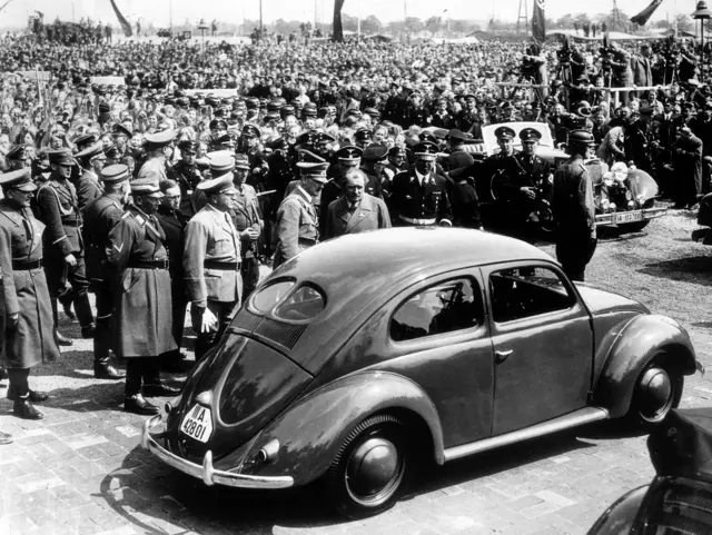 Adolf Hitler inspects a Volkswagen Beetle