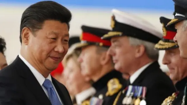 Chinese President Xi Jinping shakes hands with British officials