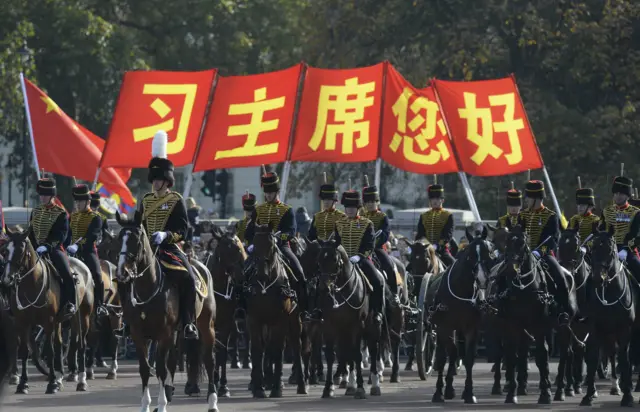 Horse-riding troops and Chinese flags in the background