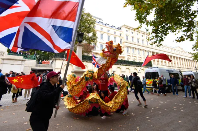 People waving flags around a Chinese dragon