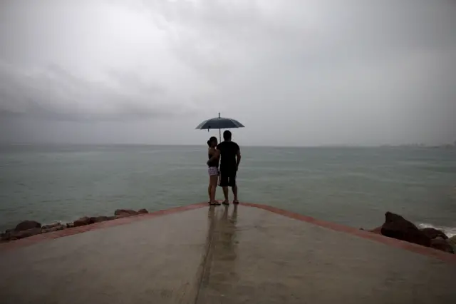 A couple looks out to sea as rainfall increases with the approach of Hurricane Patricia in Puerto Vallarta, Mexico, Friday, Oct. 23, 2015.