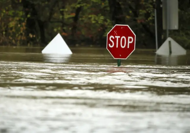 A stop sign is submerged after flooding in Dallas, Texas