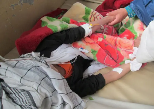 An Afghan schoolgirl injured in a stampede is comforted in her bed as she receives treatment in a hospital