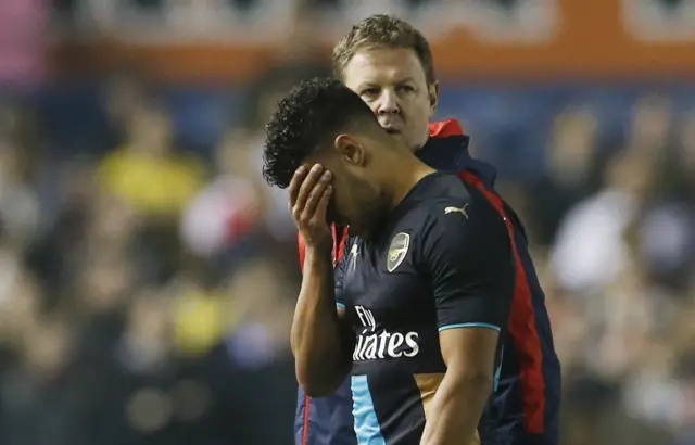 Alex Oxlade-Chamberlain reacts to an injury