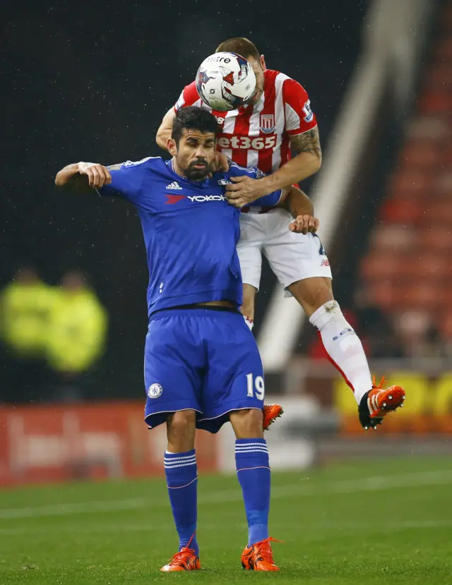 Stoke's Phil Bardsley jumps with Chelsea striker Diego Costa