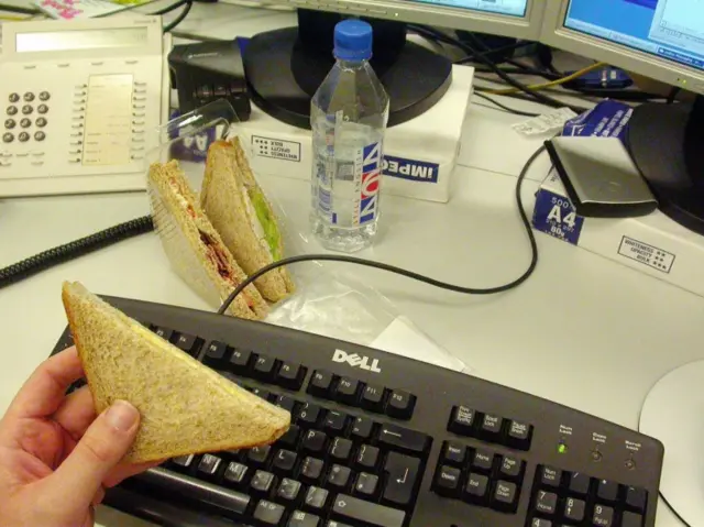 A sandwich being eaten at a desk